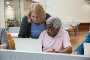 elderly people sitting in a classroom and using computers